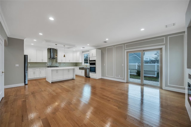 319 Blacksmith Rd W, Levittown, NY 11756 - kitchen featuring a decorative wall, black appliances, wall chimney range hood, crown molding, and plenty of natural light