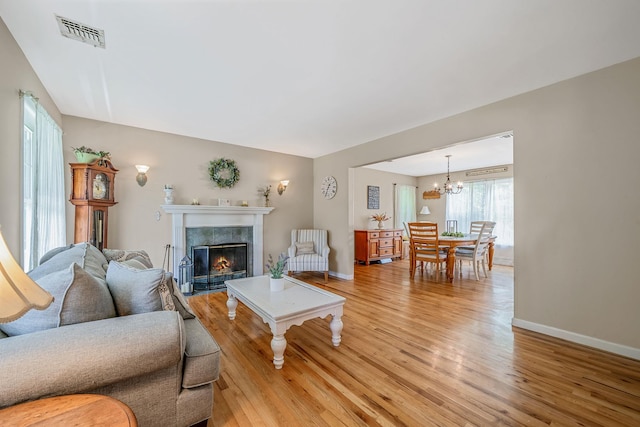 4 Ariel Ct, Rocky Point, NY 11778 - living area with light wood-type flooring, a chandelier, and a fireplace