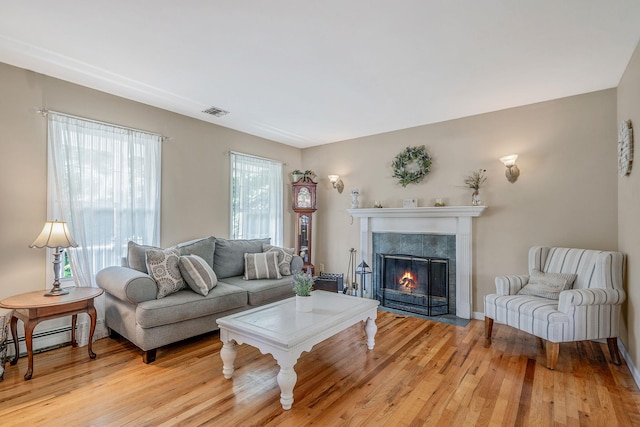 4 Ariel Ct, Rocky Point, NY 11778 - living room featuring a fireplace, light wood finished floors, and a baseboard radiator