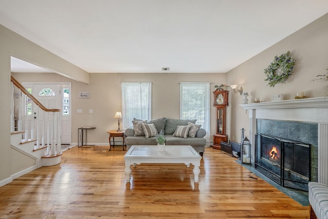 4 Ariel Ct, Rocky Point, NY 11778 - living area with plenty of natural light, a tile fireplace, light wood-type flooring, and stairway
