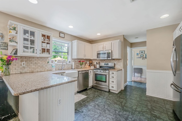 4 Ariel Ct, Rocky Point, NY 11778 - kitchen with appliances with stainless steel finishes, white cabinets, a peninsula, glass insert cabinets, and light stone counters