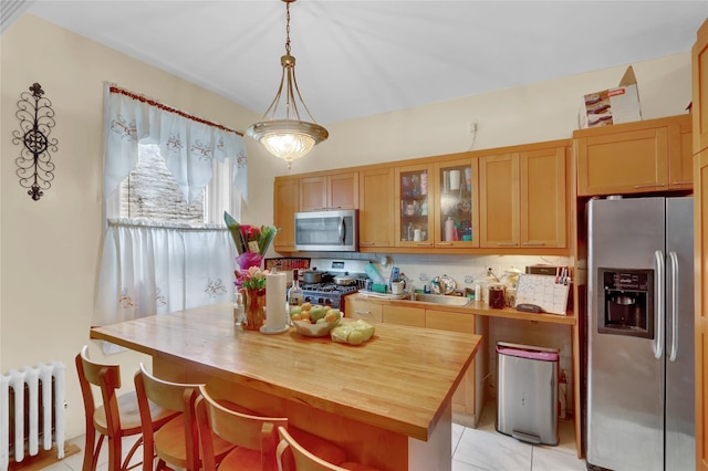 31 Tapscott St, Brooklyn, NY 11212 - kitchen with appliances with stainless steel finishes, radiator, wood counters, light tile patterned flooring, and glass insert cabinets