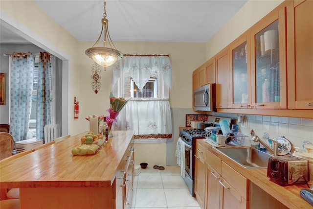 31 Tapscott St, Brooklyn, NY 11212 - kitchen featuring stainless steel appliances, wooden counters, radiator heating unit, decorative backsplash, and glass insert cabinets