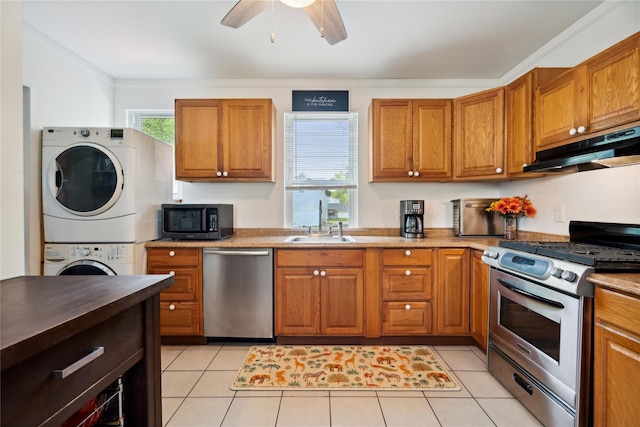 80 Diana Dr, Mastic Beach, NY 11951 - kitchen featuring stainless steel appliances, stacked washer / drying machine, under cabinet range hood, a sink, and brown cabinets