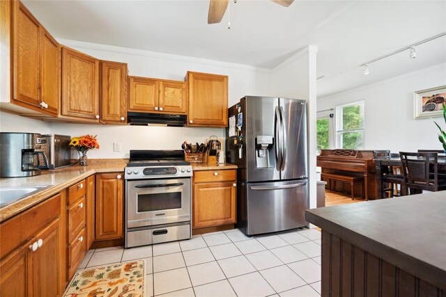 80 Diana Dr, Mastic Beach, NY 11951 - kitchen with stainless steel appliances, exhaust hood, brown cabinetry, a ceiling fan, and light tile patterned flooring