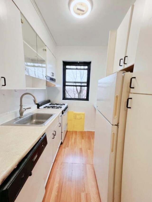 99-60 63rd Rd Unit 5W, Rego Park, NY 11374 - kitchen featuring white appliances, a sink, extractor fan, light wood-type flooring, and light countertops