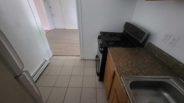 109 Garden St, Poughkeepsie, NY 12601 - kitchen featuring range with gas stovetop, a baseboard heating unit, a sink, and light tile patterned floors