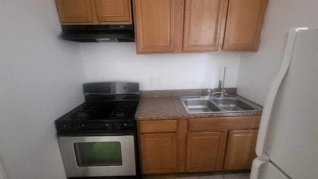 109 Garden St, Poughkeepsie, NY 12601 - kitchen with stainless steel gas range, under cabinet range hood, freestanding refrigerator, a sink, and brown cabinets