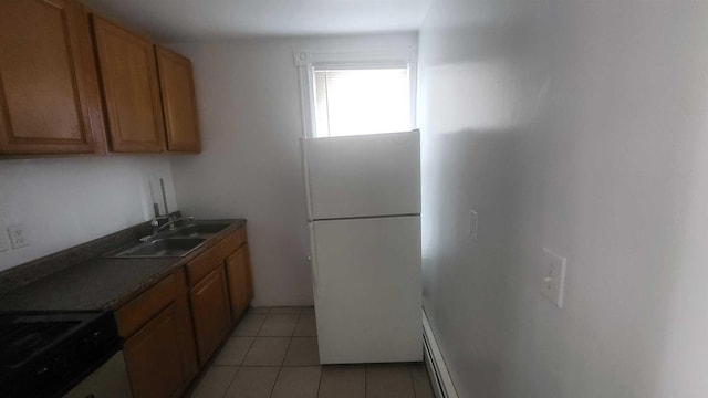 109 Garden St, Poughkeepsie, NY 12601 - kitchen with freestanding refrigerator, a sink, stove, light tile patterned floors, and brown cabinetry
