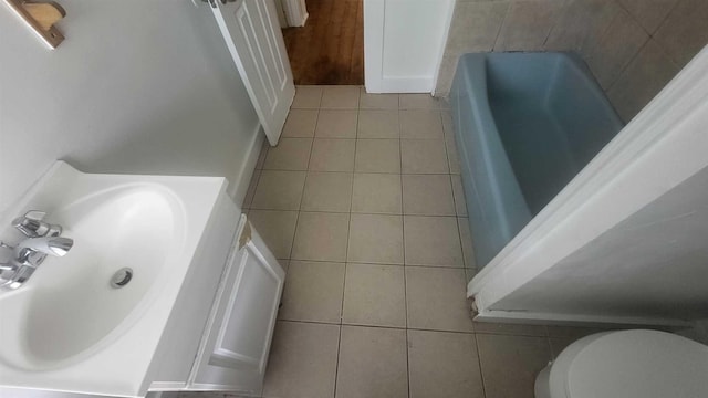 109 Garden St, Poughkeepsie, NY 12601 - bathroom featuring tile patterned floors, toilet, and a tub to relax in
