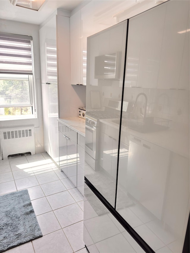 30-11 Parsons Blvd Unit 3P, Flushing, NY 11354 - kitchen featuring radiator heating unit, modern cabinets, light countertops, and washer / dryer