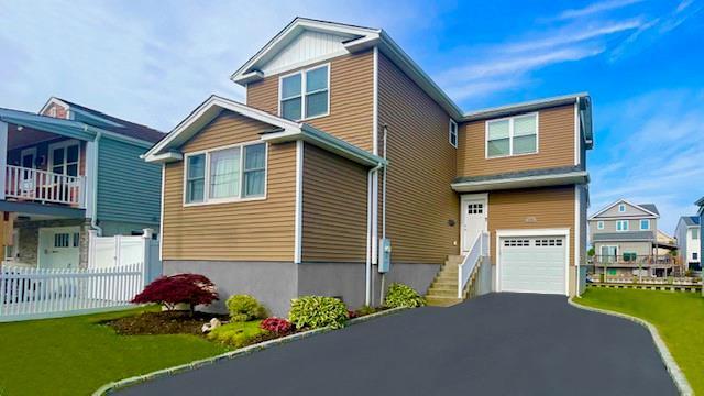 2568 Seminole Ave, Seaford, NY 11783 - view of front of property featuring an attached garage and asphalt driveway