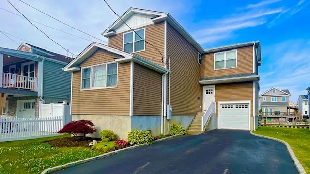 2568 Seminole Ave, Seaford, NY 11783 - view of front facade featuring a garage and asphalt driveway