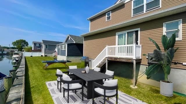 2568 Seminole Ave, Seaford, NY 11783 - back of house featuring a lawn and outdoor dining space