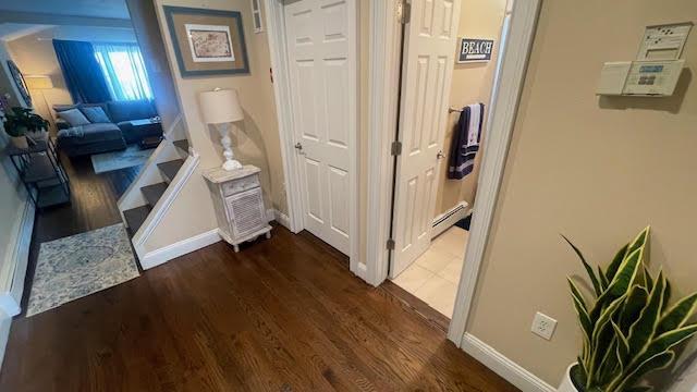 2568 Seminole Ave, Seaford, NY 11783 - corridor featuring dark wood-type flooring and a baseboard radiator