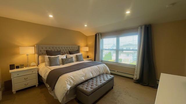 2568 Seminole Ave, Seaford, NY 11783 - carpeted bedroom with baseboard heating, vaulted ceiling, and recessed lighting