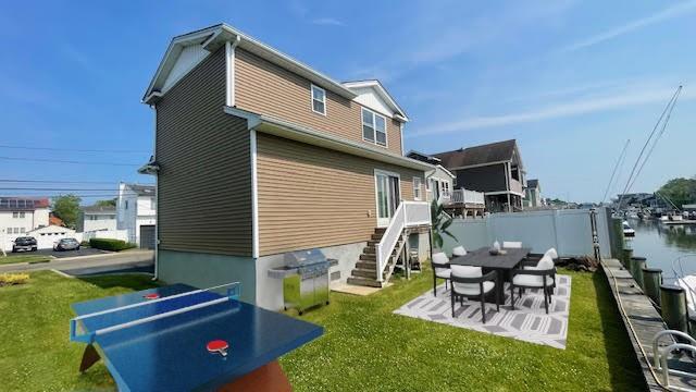 2568 Seminole Ave, Seaford, NY 11783 - rear view of house featuring stairs, a lawn, and a patio area