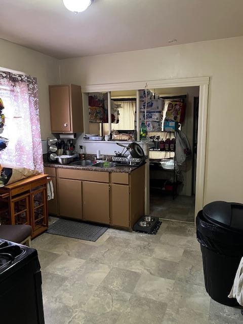 39 Harrison St, Middletown, NY 10940 - kitchen with dark countertops, black gas stove, and a sink