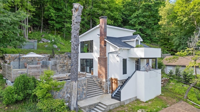 290 Mountain Rd, Pleasantville, NY 10570 - view of front of property featuring stairs, a chimney, stucco siding, a shingled roof, and a balcony