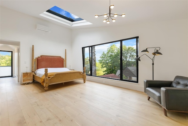 290 Mountain Rd, Pleasantville, NY 10570 - bedroom with a skylight, light wood-style flooring, a wall mounted air conditioner, a chandelier, and a towering ceiling