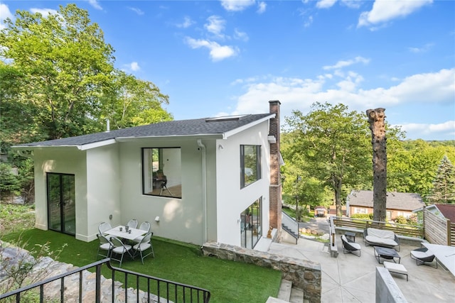 290 Mountain Rd, Pleasantville, NY 10570 - rear view of property featuring stucco siding, a patio area, a chimney, a shingled roof, and a yard
