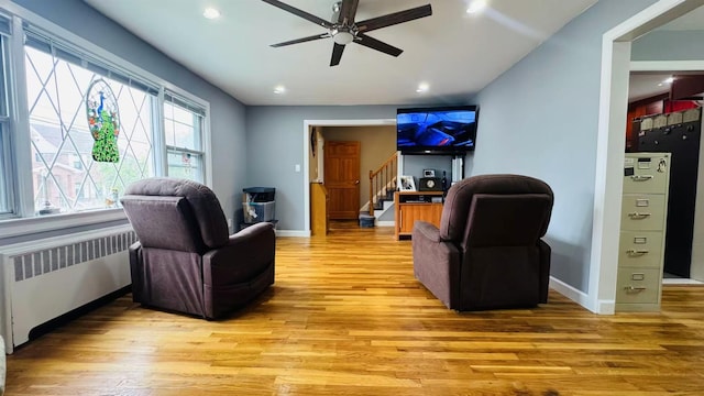 136-23 61st Rd, Flushing, NY 11367 - living area with radiator heating unit, light wood-style flooring, stairway, a ceiling fan, and baseboards
