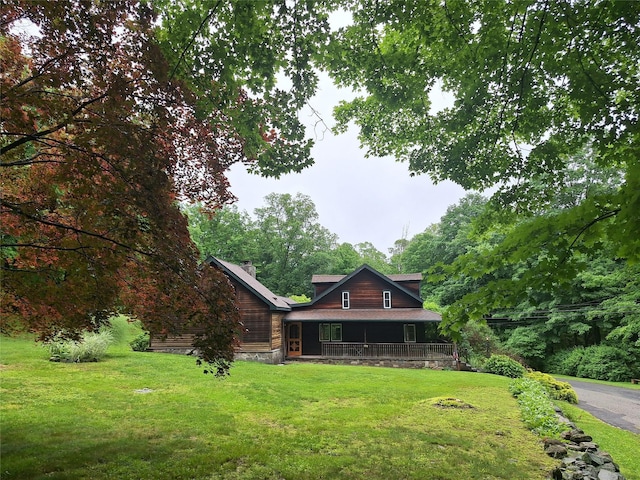 1002 Kitchawan Rd, Ossining, NY 10562 - log home with a front lawn, covered porch, and a chimney
