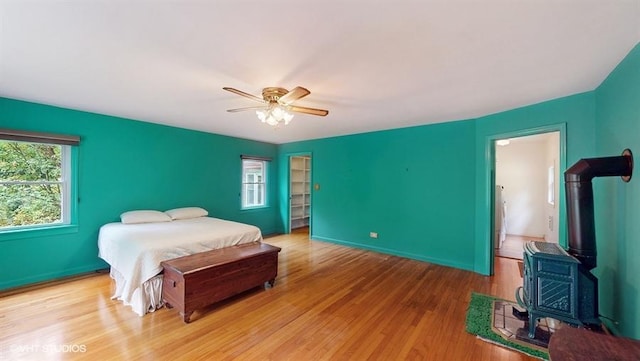 1002 Kitchawan Rd, Ossining, NY 10562 - bedroom with a wood stove, wood finished floors, and a ceiling fan