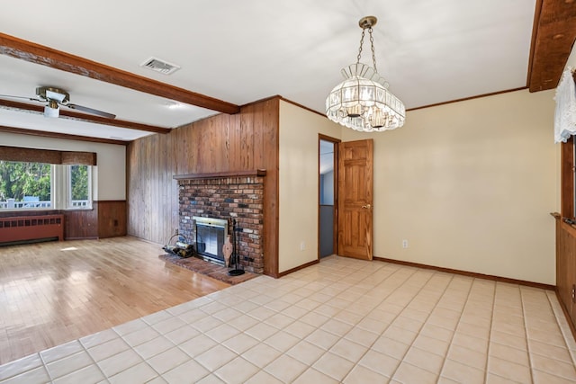 109 Dogwood Ln, Port Jefferson, NY 11777 - living room featuring radiator heating unit, wooden walls, a fireplace, beamed ceiling, and a ceiling fan
