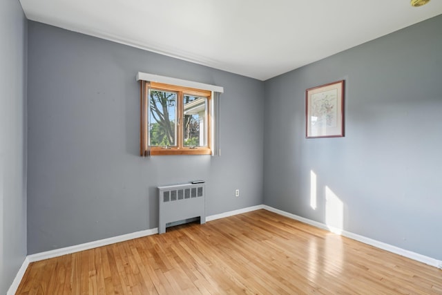 109 Dogwood Ln, Port Jefferson, NY 11777 - empty room featuring radiator, light wood-type flooring, and a smoke detector