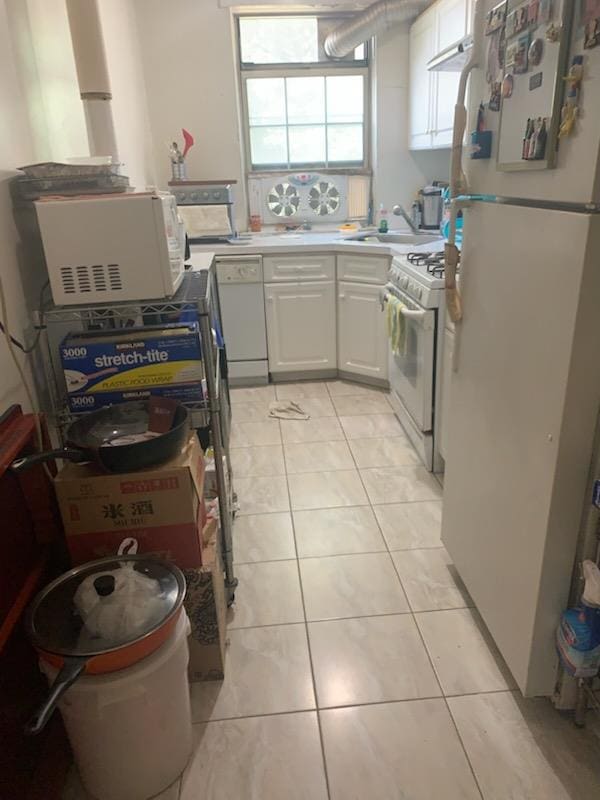 13539 78th Ave Unit 23B, Flushing, NY 11367 - kitchen with white appliances, a sink, light tile patterned flooring, and white cabinetry