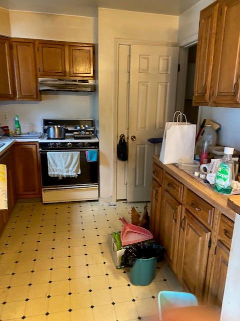 32 Centre St, Yonkers, NY 10701 - kitchen featuring range with gas stovetop, light countertops, under cabinet range hood, and brown cabinets