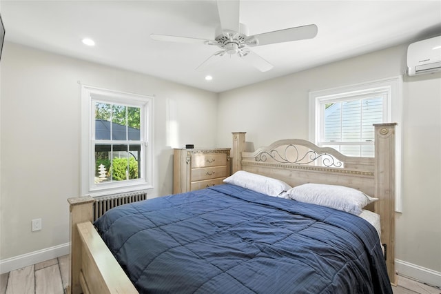 26 Fieldmere St, Elmont, NY 11003 - bedroom with radiator heating unit, a wall unit AC, light wood finished floors, recessed lighting, and ceiling fan