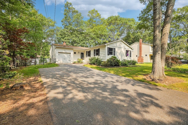 52 Iroquois Trl, Ridge, NY 11961 - view of front of property featuring asphalt driveway, a garage, a chimney, and board and batten siding
