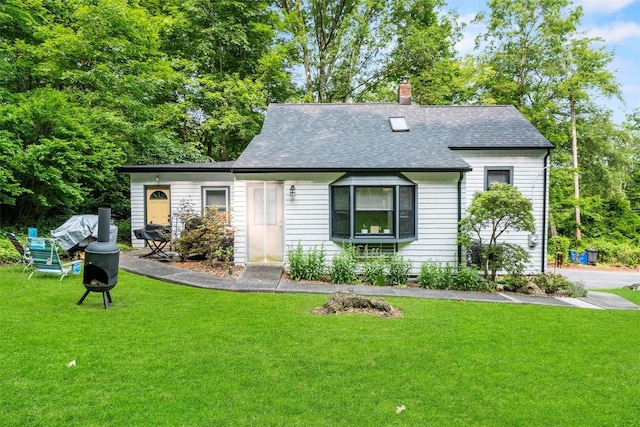 1302 Rte 22 Unit 1300, Brewster, NY 10509 - view of front facade featuring roof with shingles, a front lawn, a chimney, and an outdoor fire pit