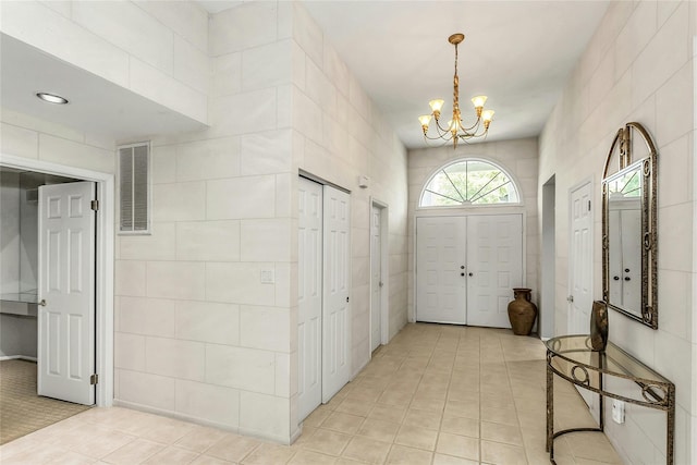 165 Country Club Dr, Commack, NY 11725 - foyer entrance with a chandelier, tile walls, and light tile patterned floors