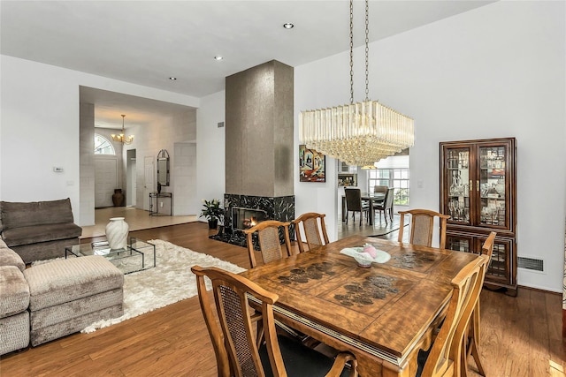 165 Country Club Dr, Commack, NY 11725 - dining space with a chandelier, wood finished floors, plenty of natural light, and a premium fireplace