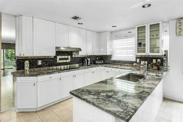 165 Country Club Dr, Commack, NY 11725 - kitchen with a sink, under cabinet range hood, white cabinets, a peninsula, and decorative backsplash