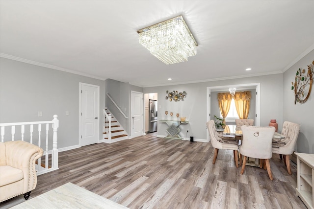 2716 Beach Dr, Merrick, NY 11566 - dining room with a chandelier, wood finished floors, stairs, crown molding, and recessed lighting