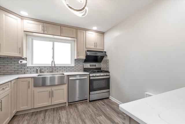 2716 Beach Dr, Merrick, NY 11566 - kitchen with stainless steel appliances, a sink, tasteful backsplash, light wood-type flooring, and recessed lighting