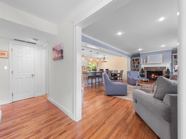 15 Tennyson Dr, Nanuet, NY 10954 - living area with light wood-style flooring, baseboards, a stone fireplace, ornamental molding, and recessed lighting