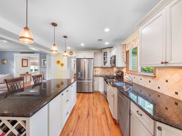 15 Tennyson Dr, Nanuet, NY 10954 - kitchen with stainless steel appliances, light wood-type flooring, glass insert cabinets, pendant lighting, and recessed lighting