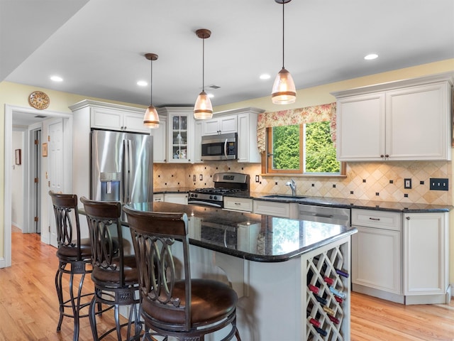 15 Tennyson Dr, Nanuet, NY 10954 - kitchen with appliances with stainless steel finishes, a kitchen breakfast bar, a center island, light wood finished floors, and glass insert cabinets