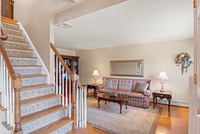 81 Brunswick Rd, Ronkonkoma, NY 11779 - living area featuring baseboard heating, stairway, and wood finished floors