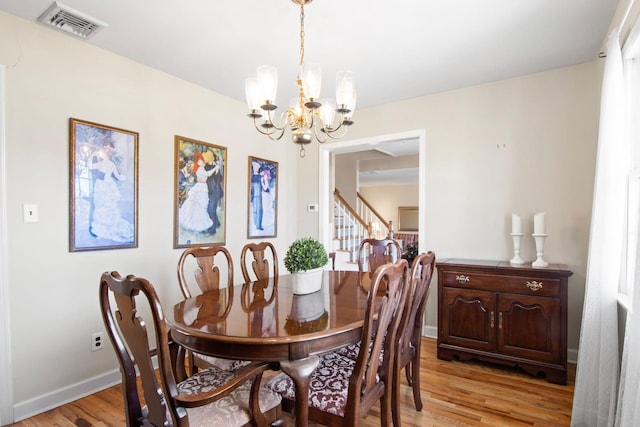 81 Brunswick Rd, Ronkonkoma, NY 11779 - dining room with a chandelier, light wood-style flooring, stairway, and baseboards