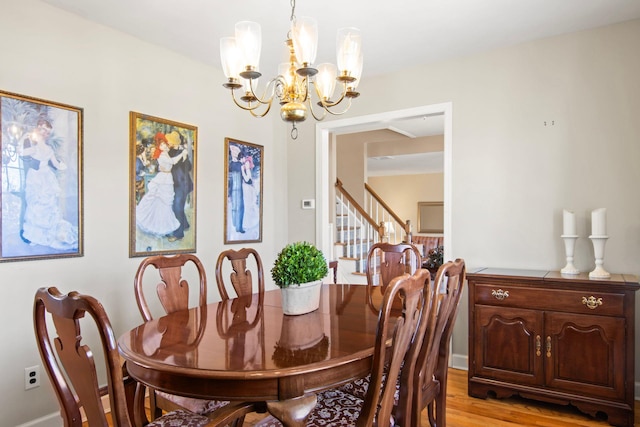 81 Brunswick Rd, Ronkonkoma, NY 11779 - dining room with a chandelier, light wood-style floors, and stairs