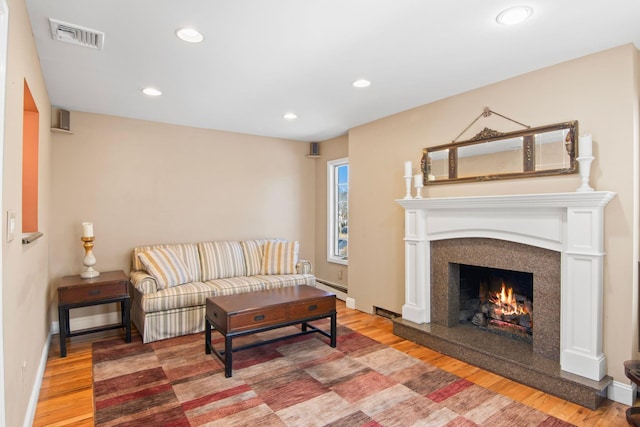 81 Brunswick Rd, Ronkonkoma, NY 11779 - living room featuring wood finished floors, a fireplace, baseboard heating, and recessed lighting