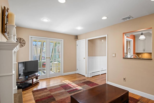 81 Brunswick Rd, Ronkonkoma, NY 11779 - living area featuring french doors, baseboard heating, wood finished floors, baseboards, and recessed lighting