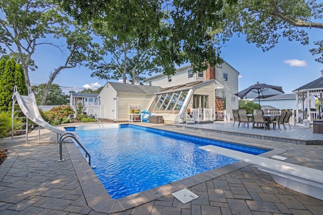 81 Brunswick Rd, Ronkonkoma, NY 11779 - outdoor pool featuring a water slide, a sunroom, a patio area, outdoor dining area, and a diving board