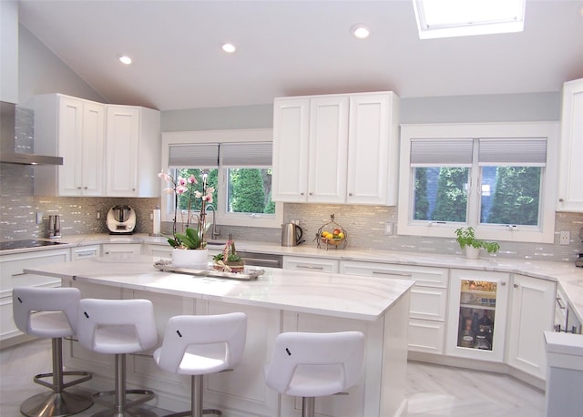 12 Sound View Dr, Rocky Point, NY 11778 - kitchen featuring a kitchen bar, lofted ceiling, tasteful backsplash, white cabinets, and black electric stovetop